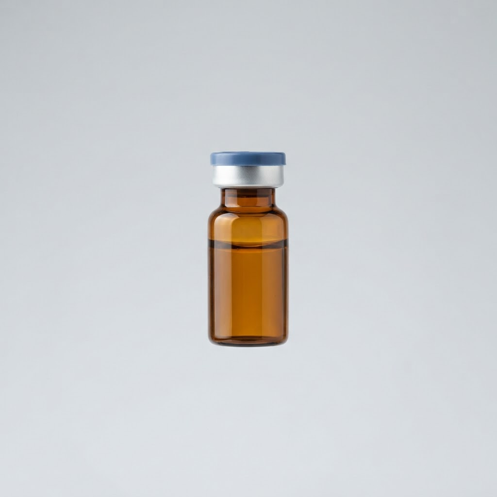 A small amber glass injectable vial with an aluminum crimp cap